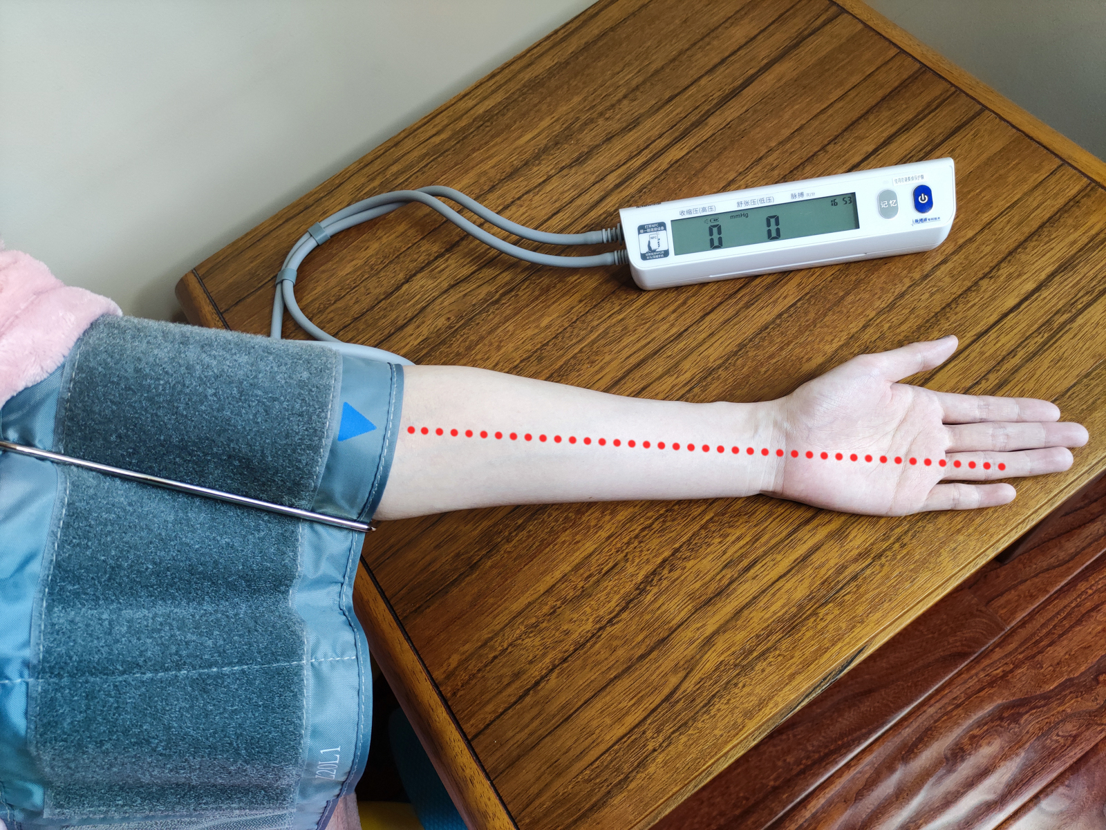 将双气囊袖带套在被测上臂,三角标指示箭头正对无名指方向:   将手臂